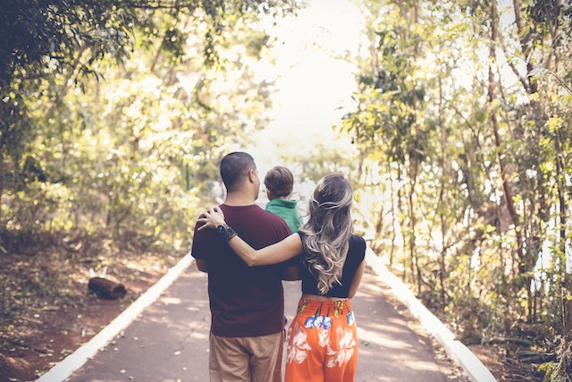 A family walking away through a park